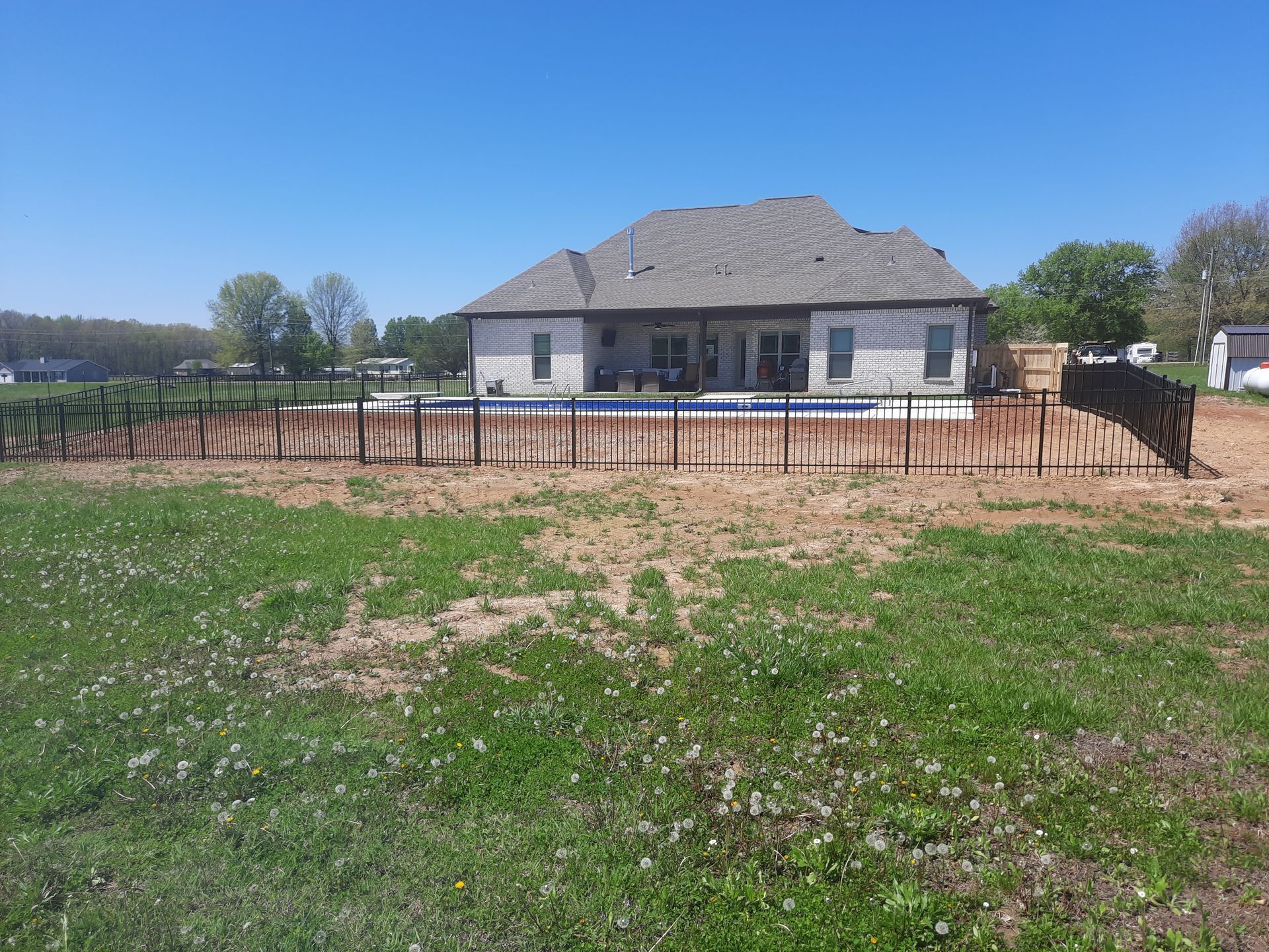 A house with a pool in the backyard and a fence around it.