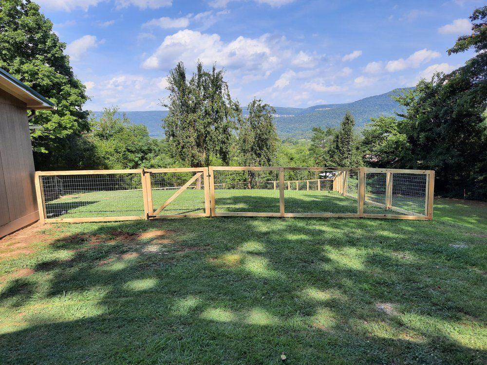 A wooden fence is sitting in the middle of a lush green field.