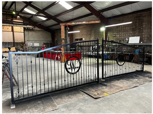 A wrought iron gate is sitting in a warehouse.