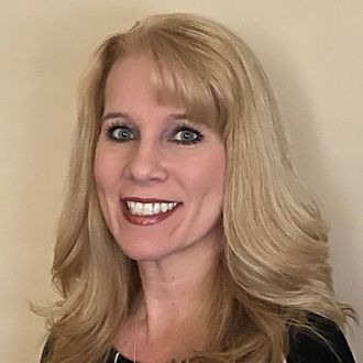 Donna Berube, the owner of Berube Insurance, is smiling and looking at the camera.