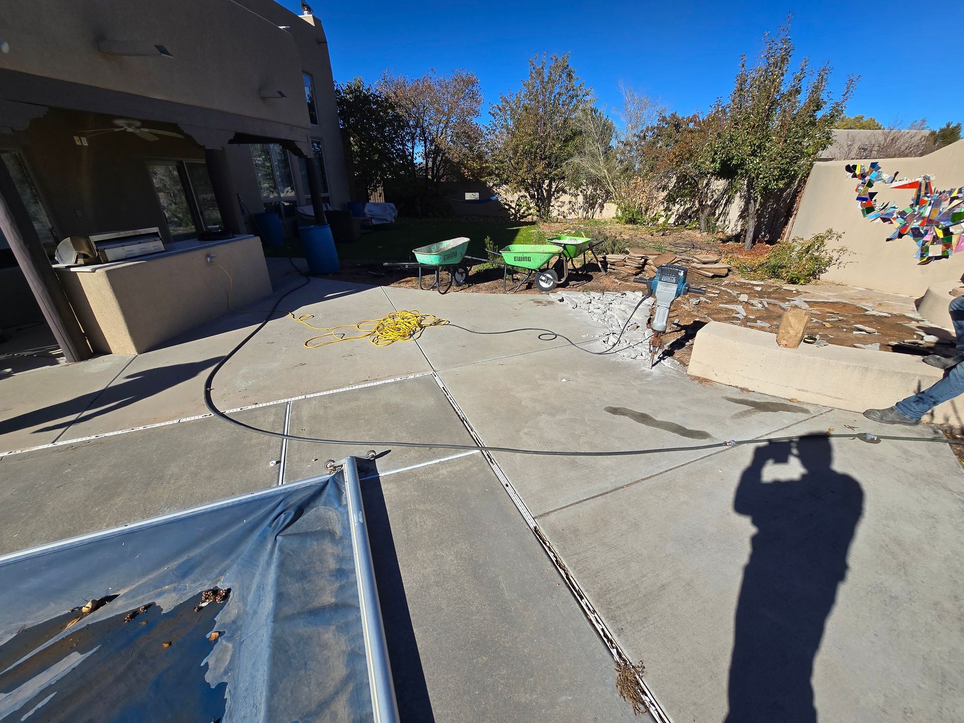 A man is taking a picture of his shadow on the sidewalk