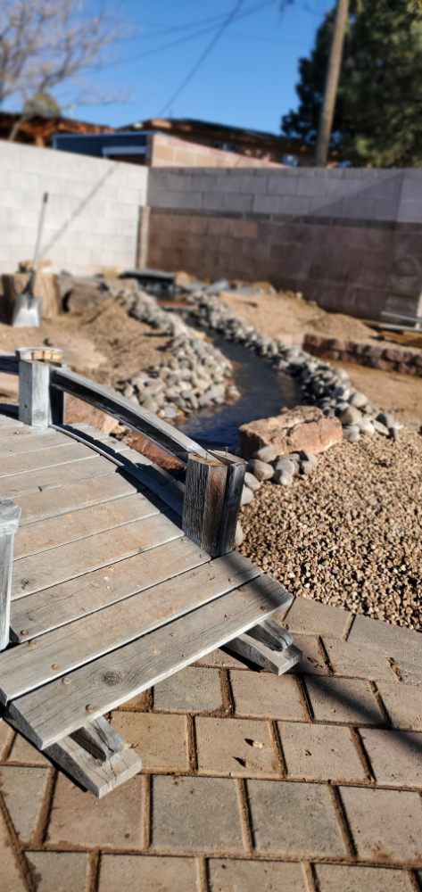 A wooden deck is sitting on top of a brick patio.