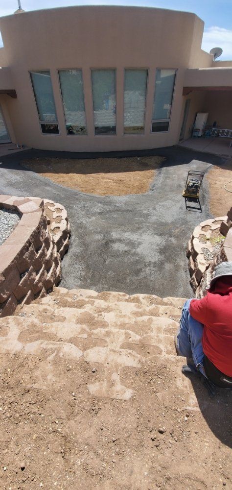 A man is sitting on a set of stairs in front of a large house.