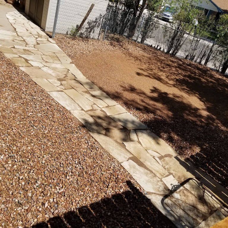 A shadow of a person is cast on a stone walkway