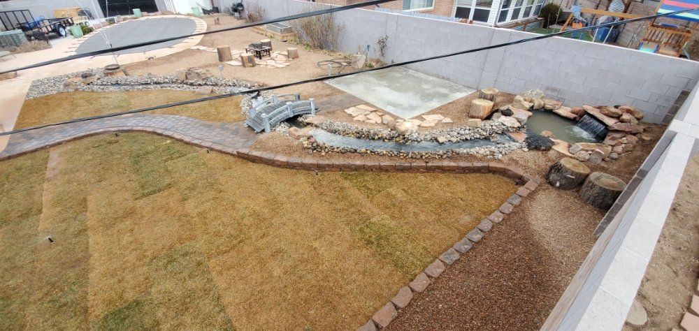 An aerial view of a backyard with a pond and a walkway.