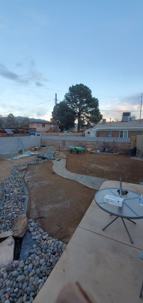 A patio with a table and chairs in the backyard of a house.
