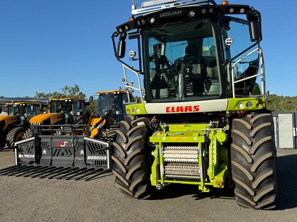 Three yellow JCB agricultural tractors parked on a gravel lot, the front one equipped with a large black