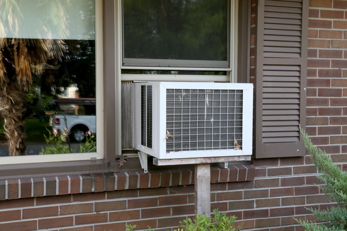 A Window Air Conditioner Is Mounted on The Side of A Brick Building — Northernair in East Lismore, NSW