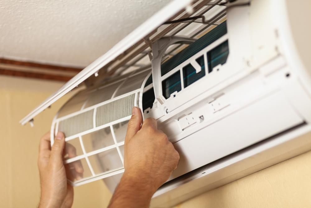 A Person Is Cleaning the Filter of An Air Conditioner — Northernair in Byron Bay, NSW