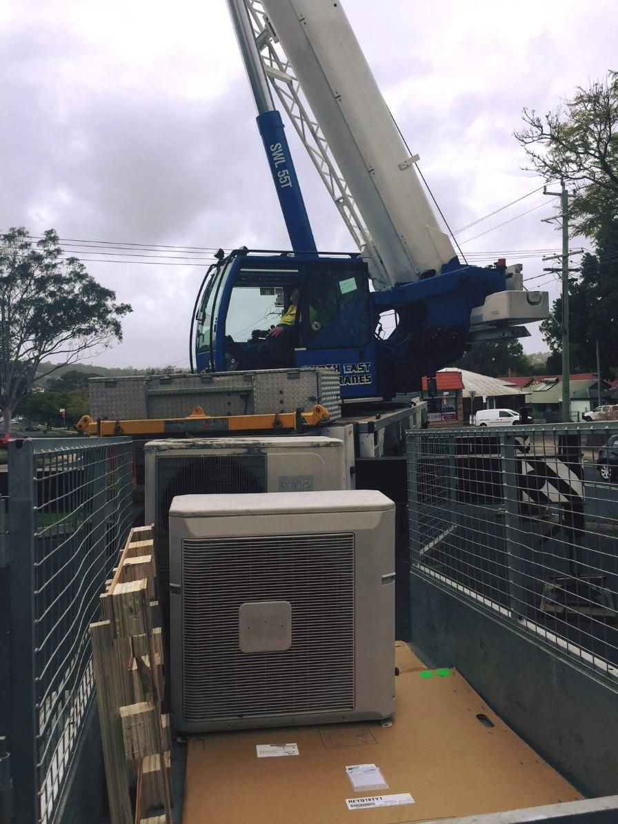 A Blue and White Crane Is Lifting a Box in The Back of A Truck — Northernair in Brunswick Heads, NSW