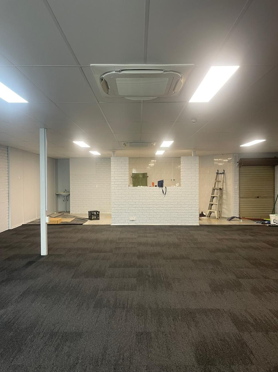 A Large Empty Room with A Carpeted Floor and Air Conditioner — Northernair in Byron Bay, NSW