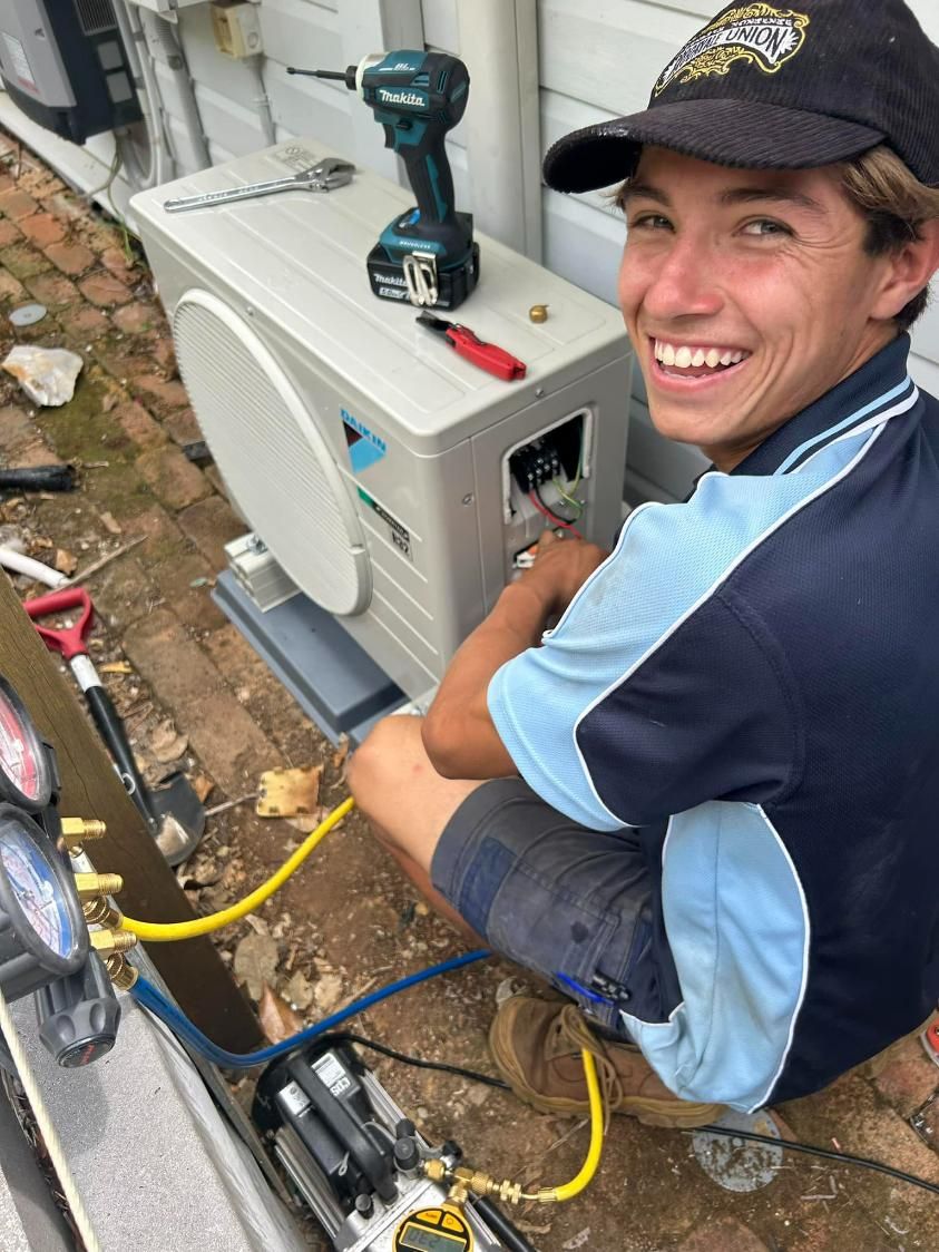 A Young Man Is Working on An Air Conditioner Outside of A House — Northernair in East Lismore, NSW