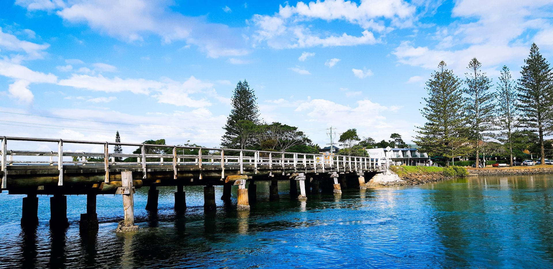 A Wooden Bridge Over a Body of Water With Trees in the Background — Northernair in East Lismore, NSW