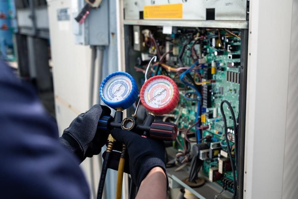 A Man Is Working on An Air Conditioner with Two Gauges on It — Northernair in East Lismore, NSW