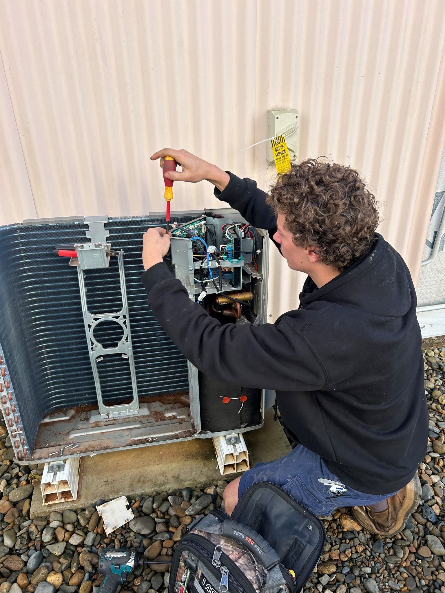  Person Repairs an Air Conditioning Unit Outdoors