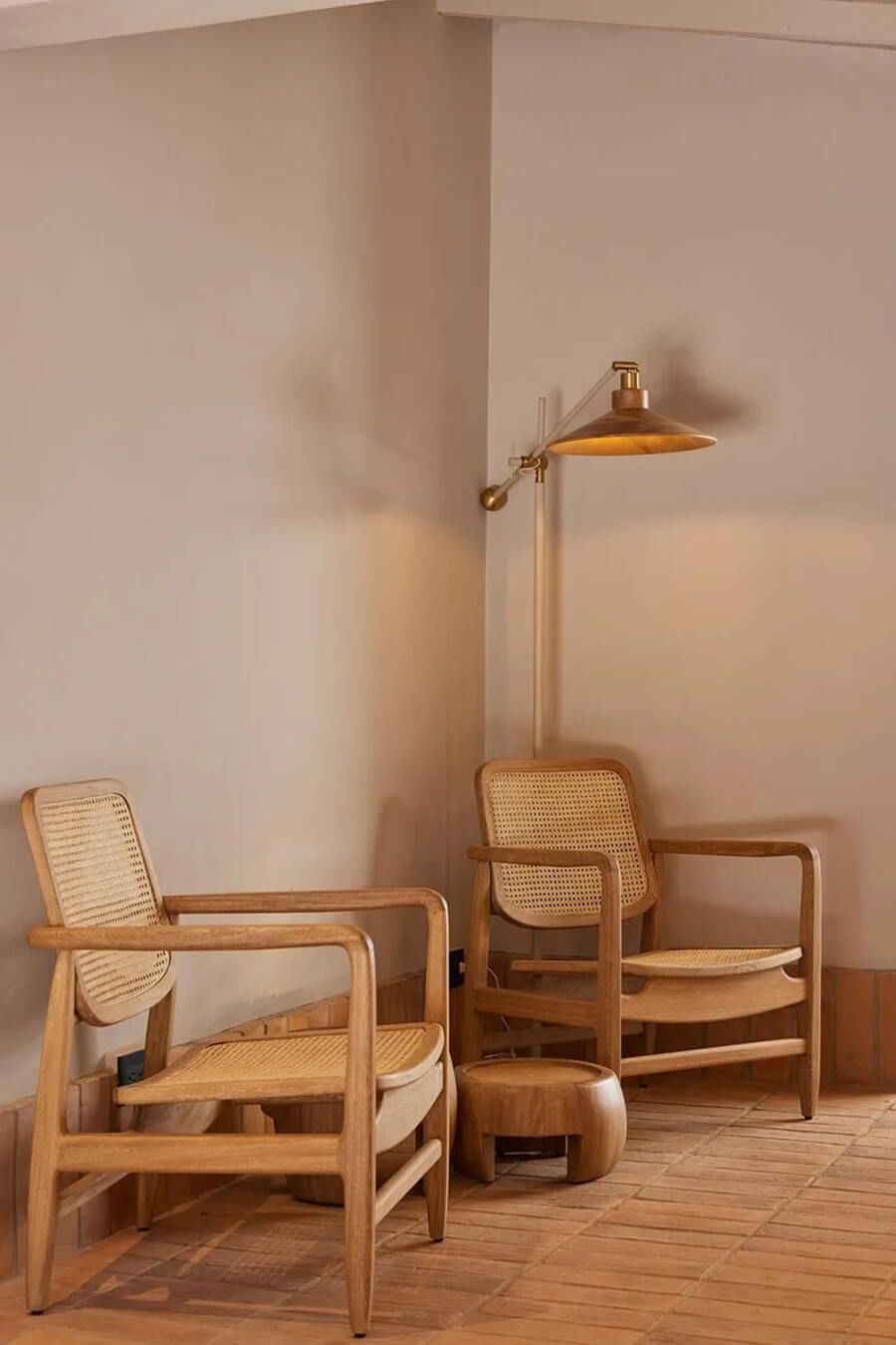 Rincón acogedor con dos sillas de madera y una lámpara de pie en un espacio minimalista