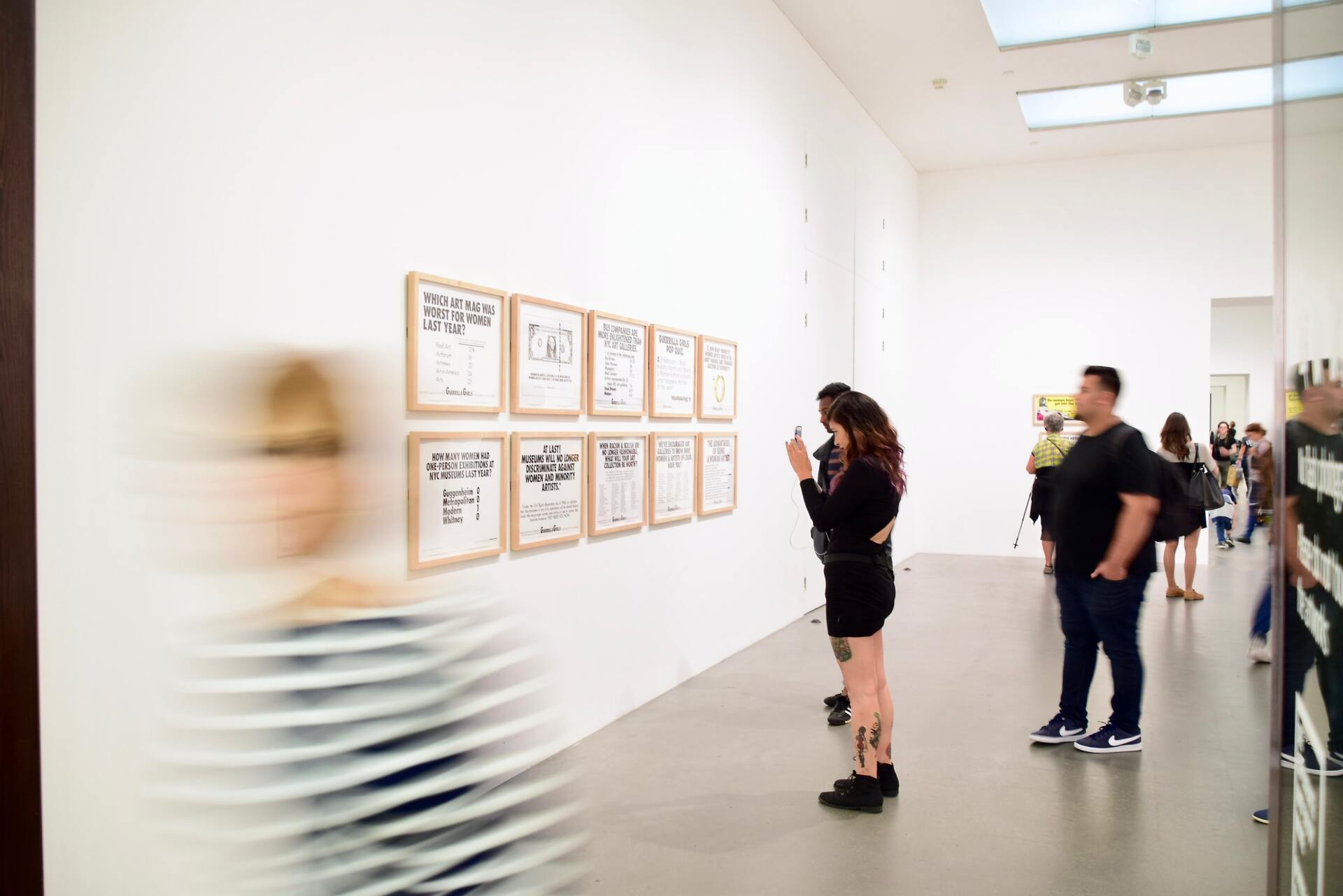 Menschen betrachten Bilder in einem Museum.