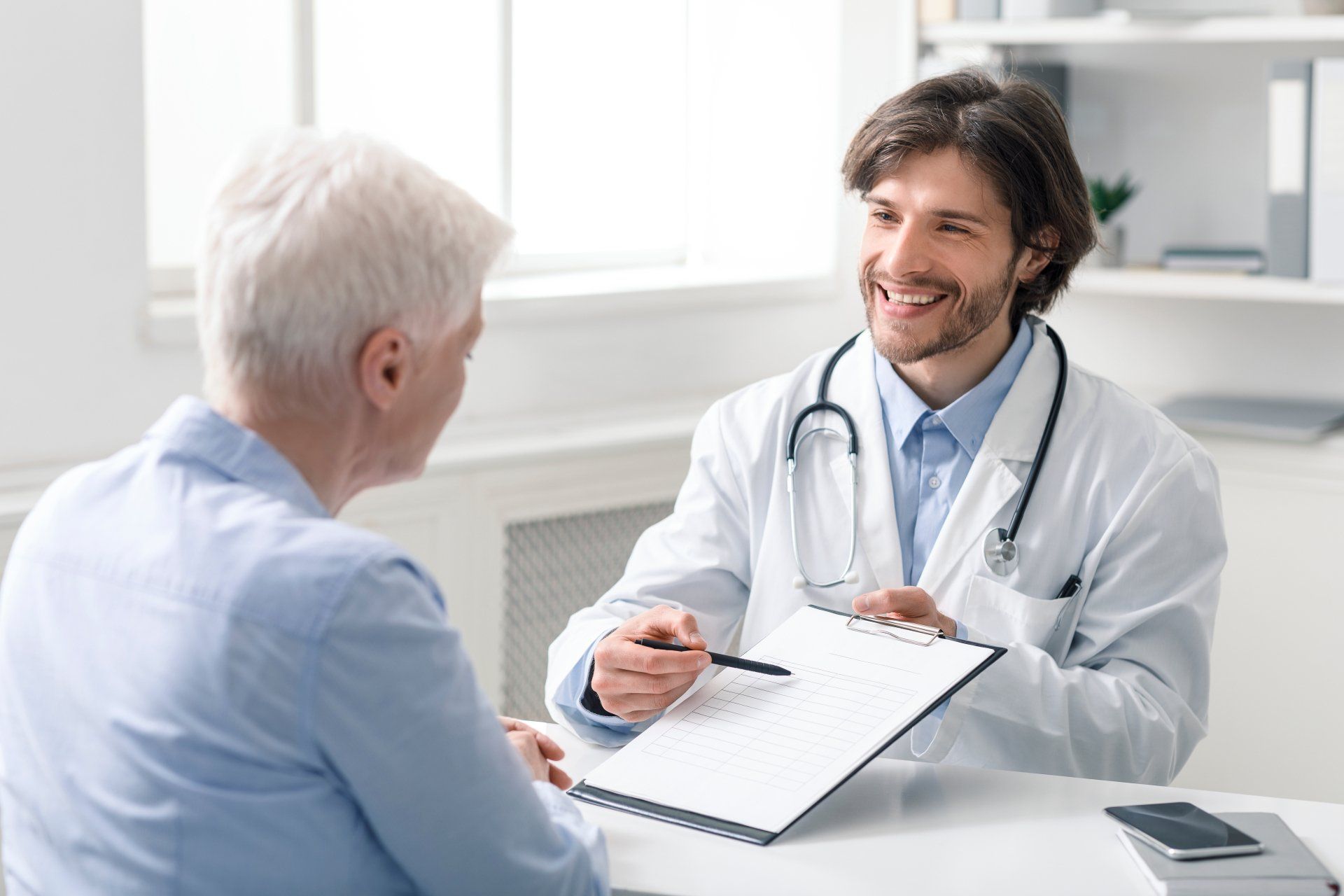 Ein Arzt erklärt einer Patientin etwas.