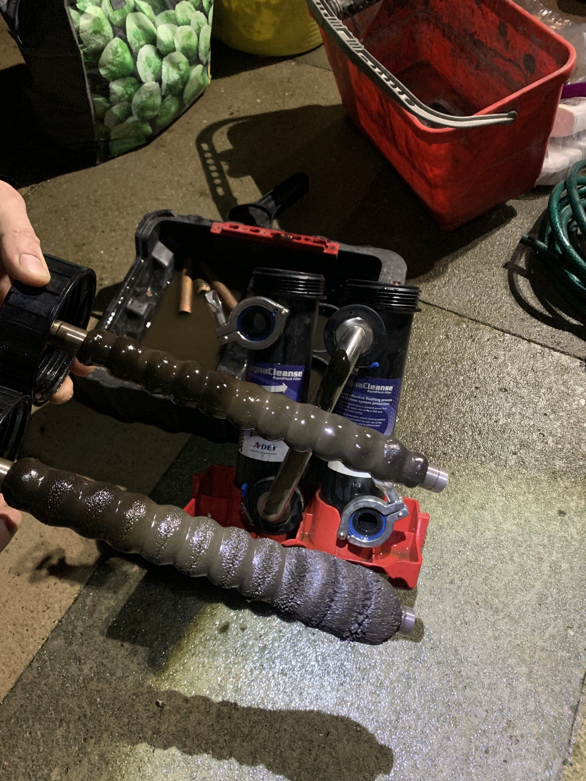 Three dirty, cylindrical tools and other equipment on a wet surface.