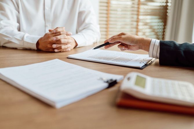 A man and a woman are sitting at a table having a job interview | F & M Automotive Body & Repair