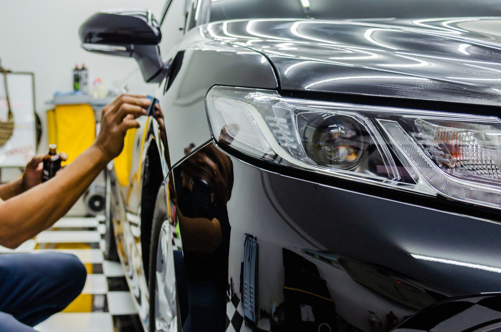 A man is polishing a car in a garage | F & M Automotive Body & Repair
