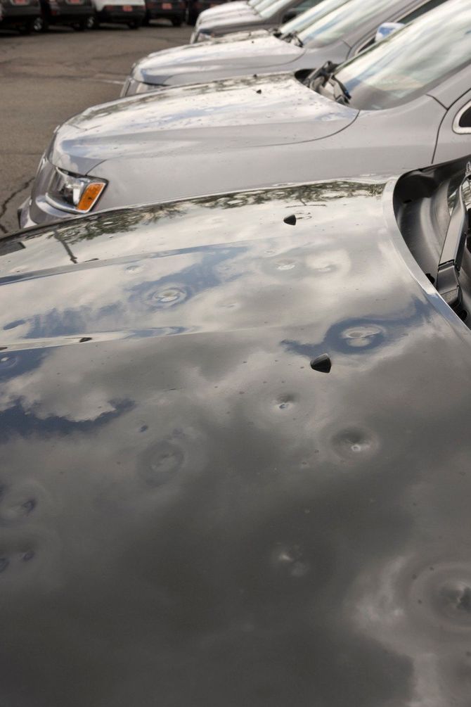 A row of cars are parked next to each other in a parking lot.