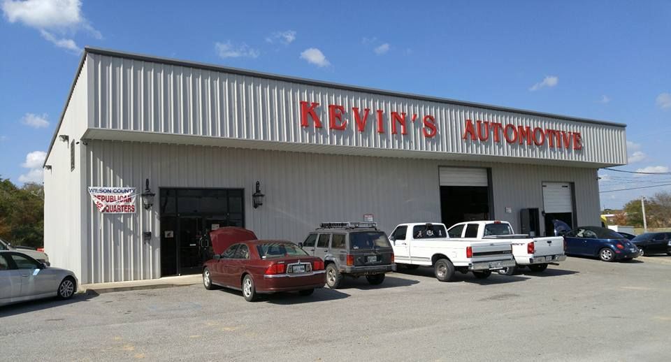 Kevin's Automotive repair shop with cars parked outside, sunny day. Red sign.