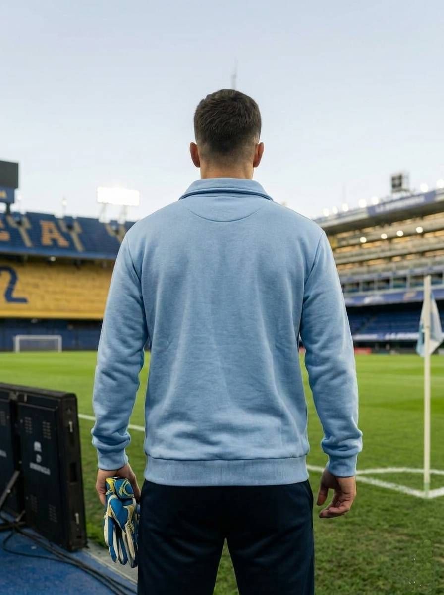 Jugador de fútbol con la camiseta azul celeste y blanca de Argentina con el número 10, de pie en el césped de un estadio.
