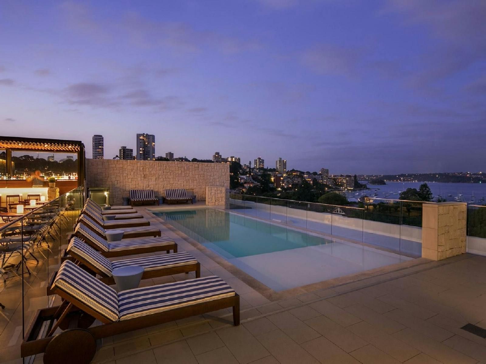 Five star hotel rooftop pool overlooking city skyline luxury travel experience