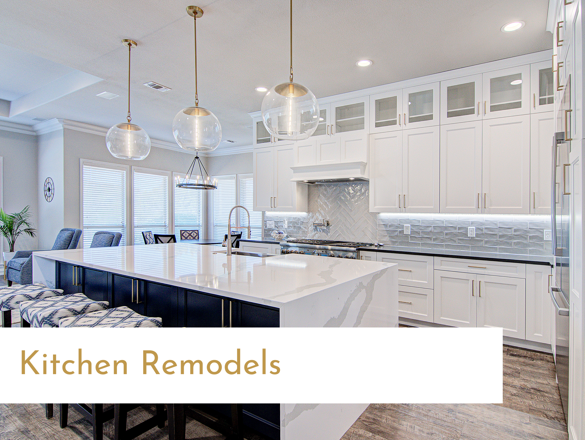 A kitchen with white cabinets , black counter tops , and a large island.