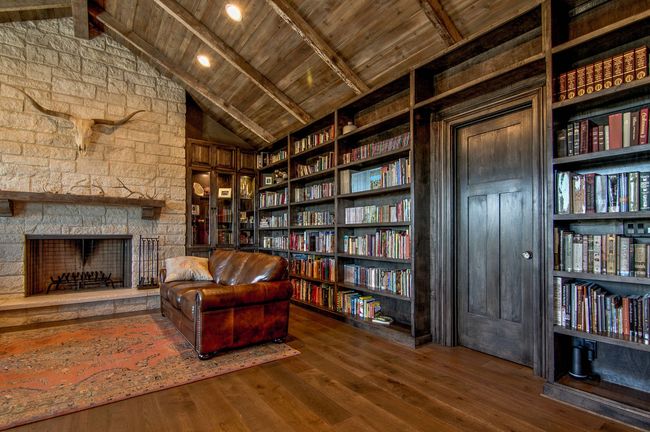 A living room filled with furniture and bookshelves and a fireplace.