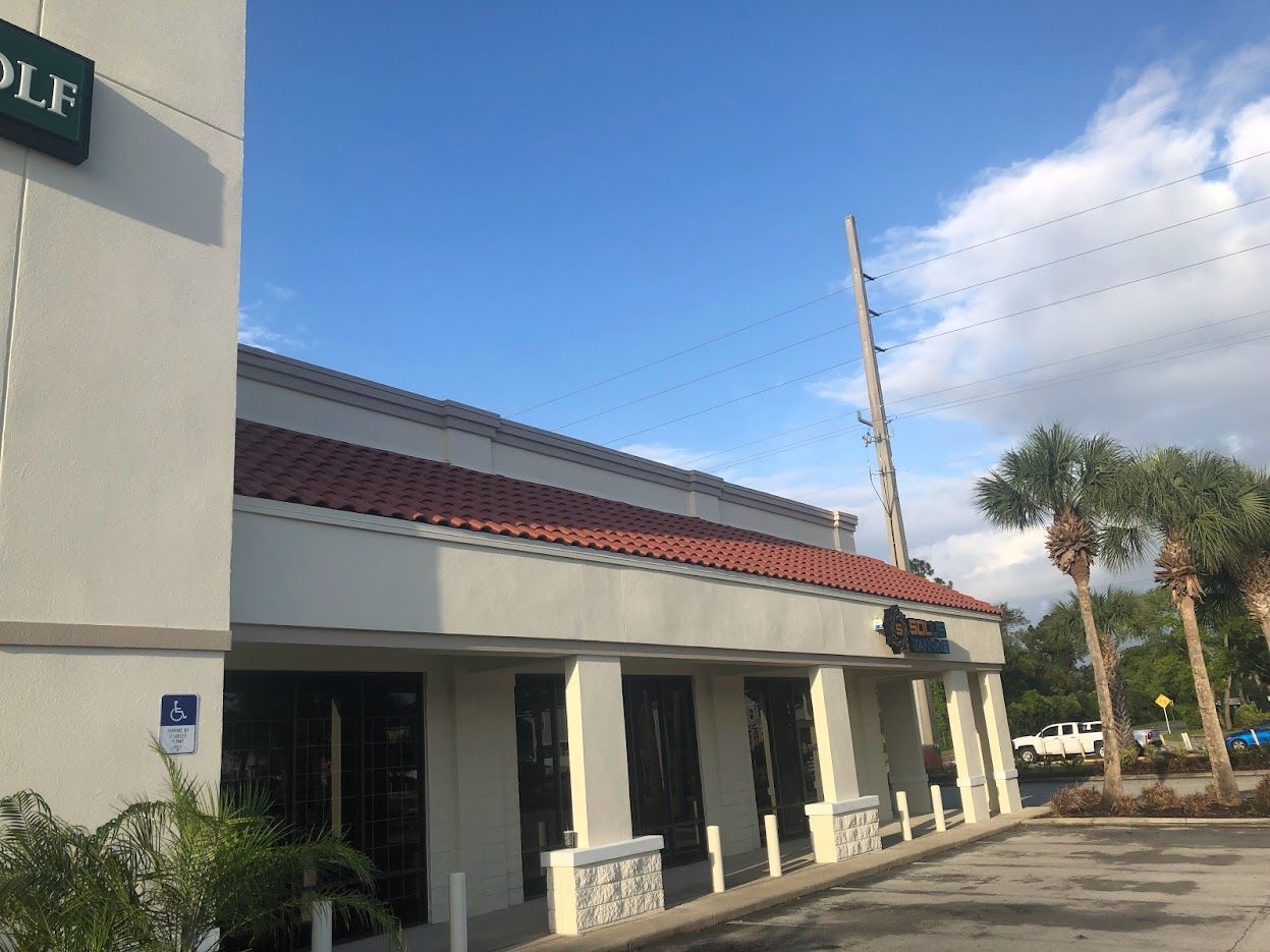 Exterior of a building with a tile roof, sign says 