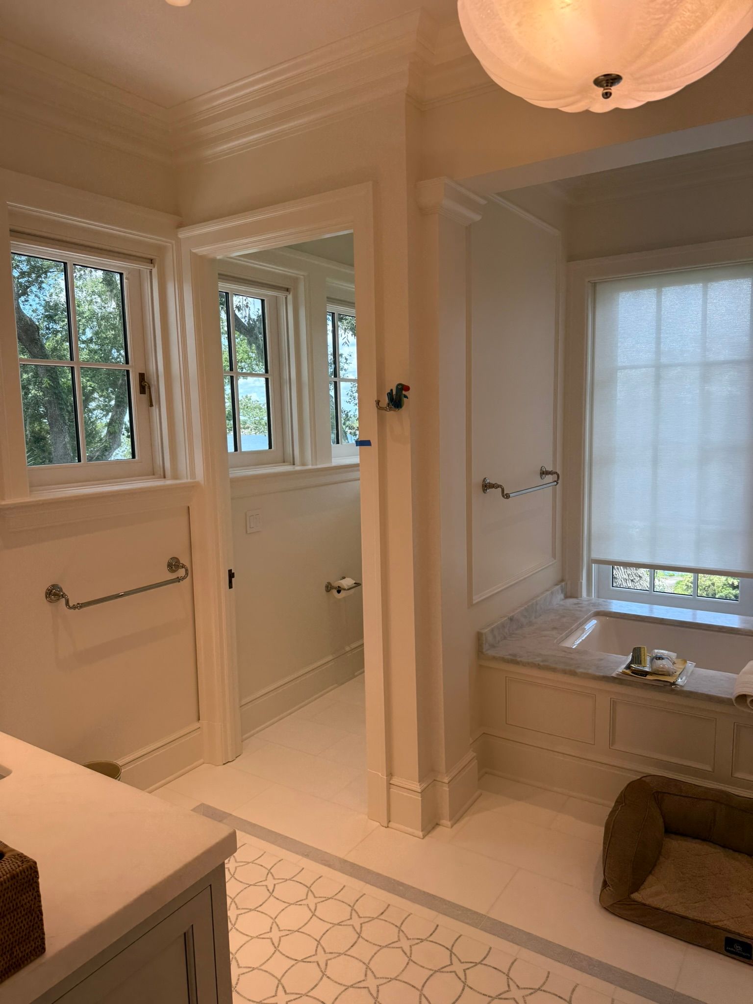 Bright bathroom with windows, tub, and shower area in warm beige tones