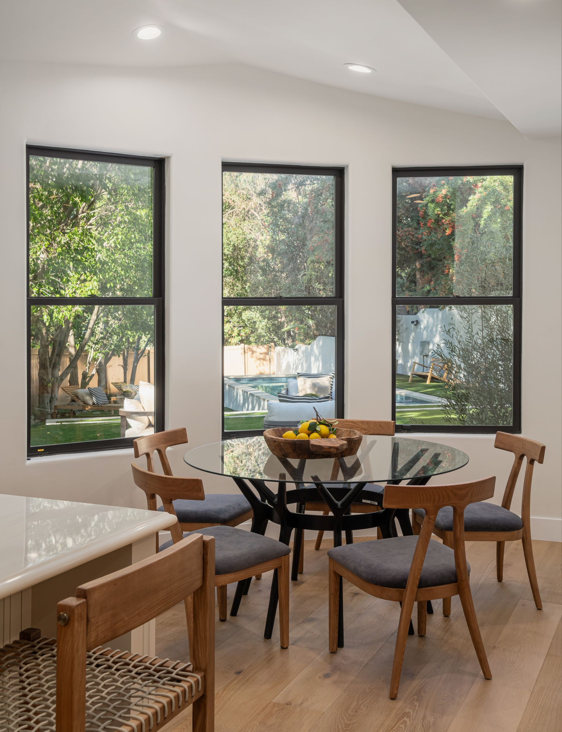 A dining room with a table and chairs and lots of windows