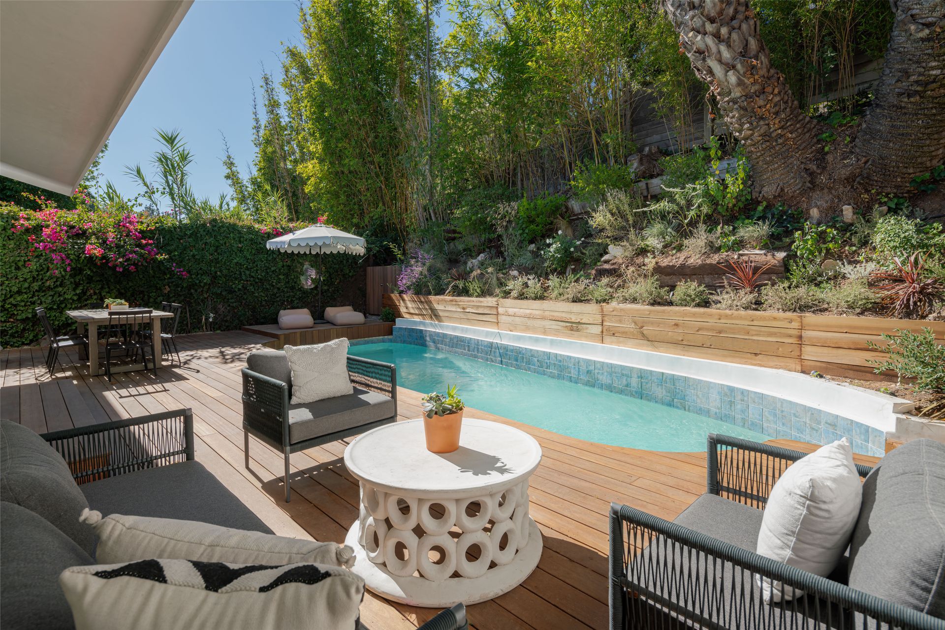 There is a large swimming pool in the backyard of a house.