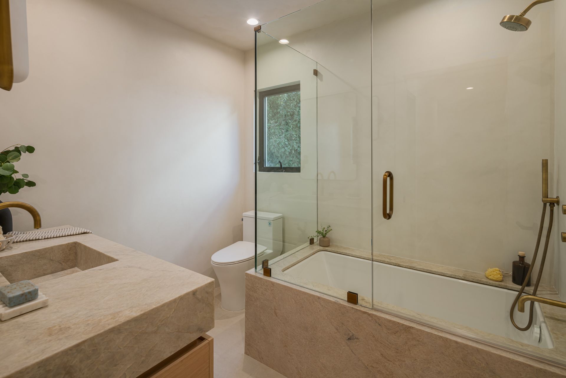 A bathroom with a bathtub , toilet , sink and shower.