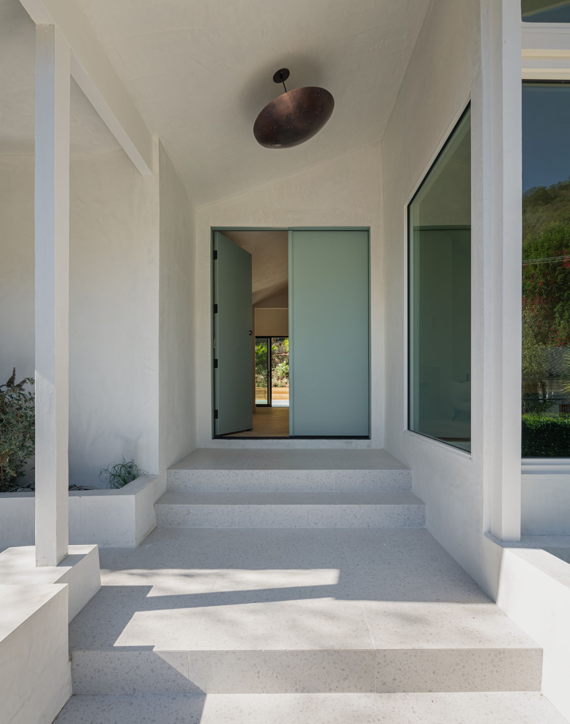 A white house with a blue door and stairs