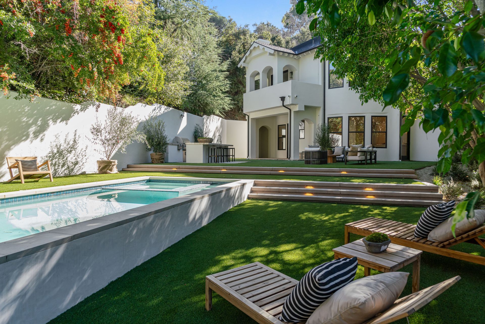 There is a large swimming pool in the backyard of a house.