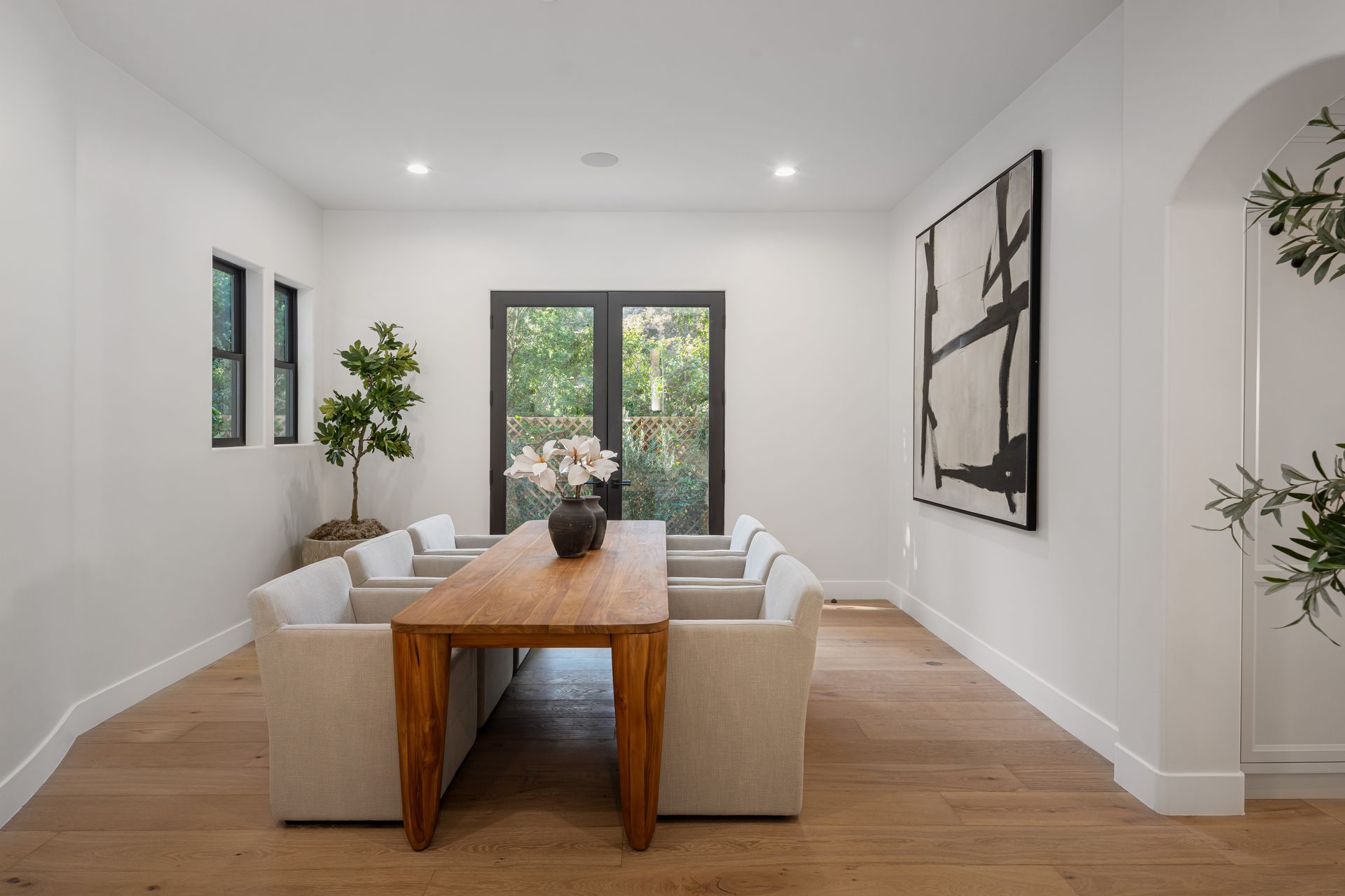 A living room with a table and chairs and a painting on the wall.
