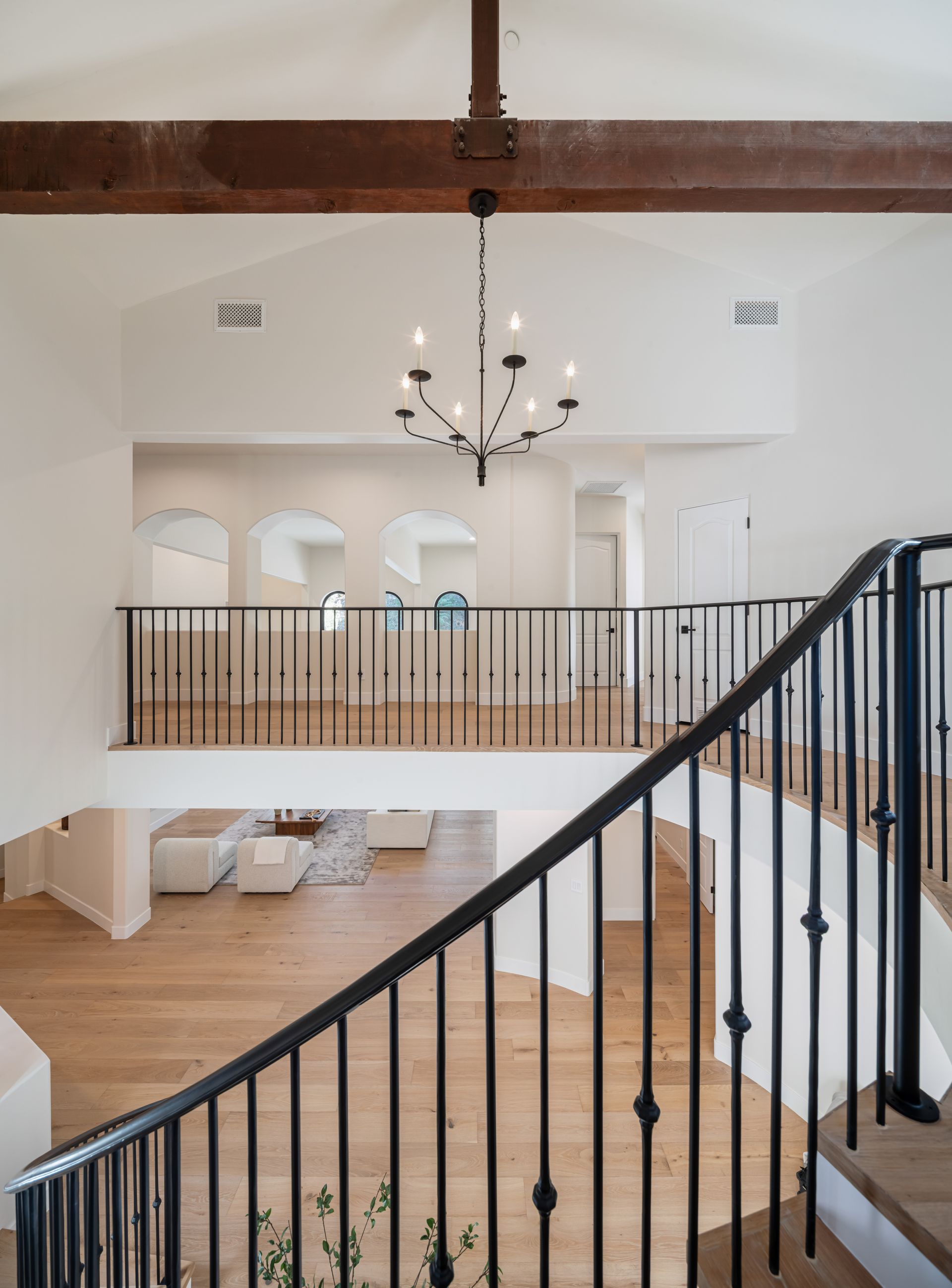 A staircase in a house with a chandelier hanging from the ceiling