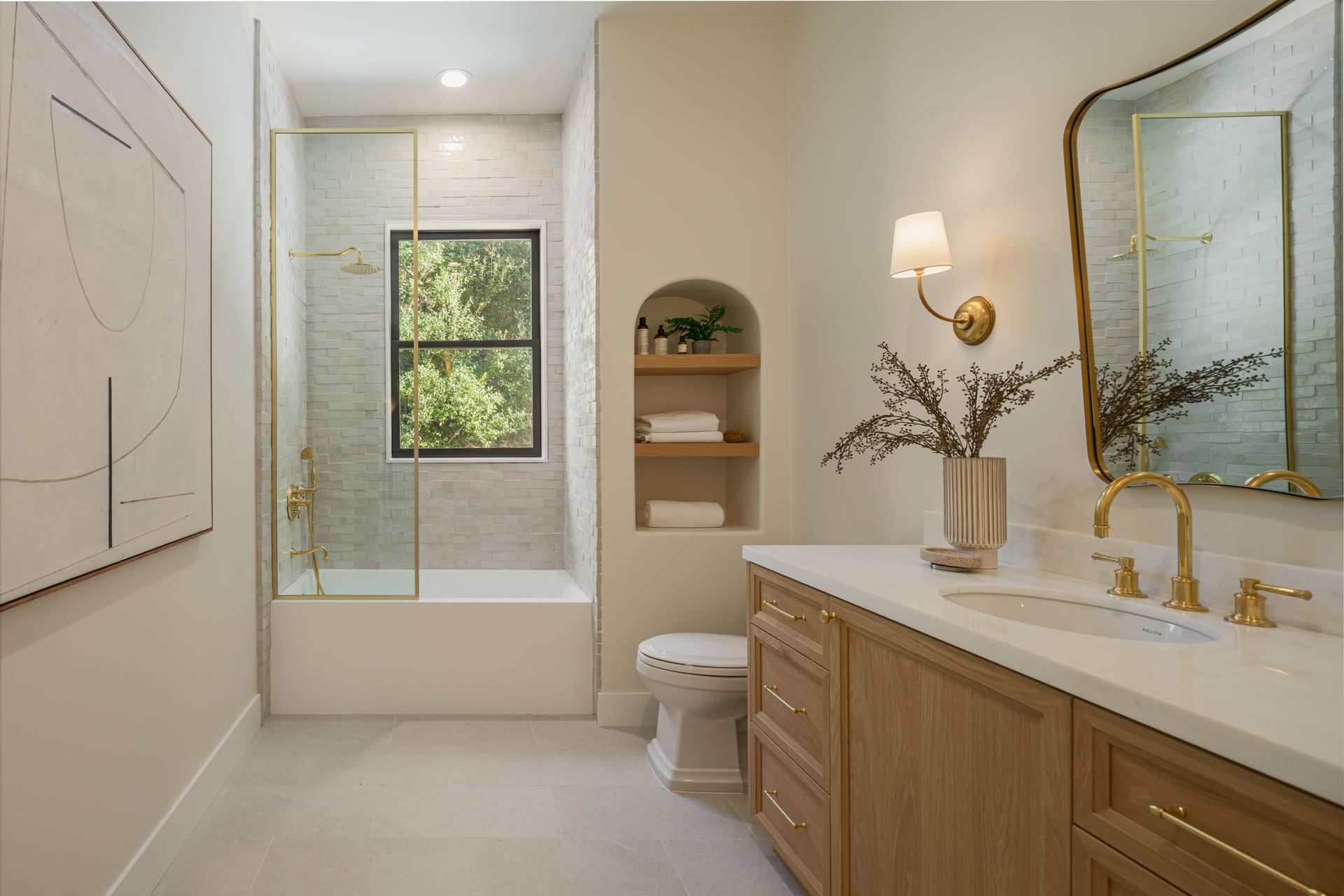 A bathroom with a sink , toilet , shower and window.
