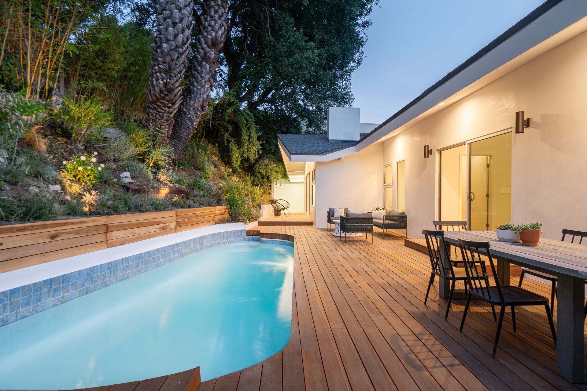 There is a large swimming pool in the backyard of a house.