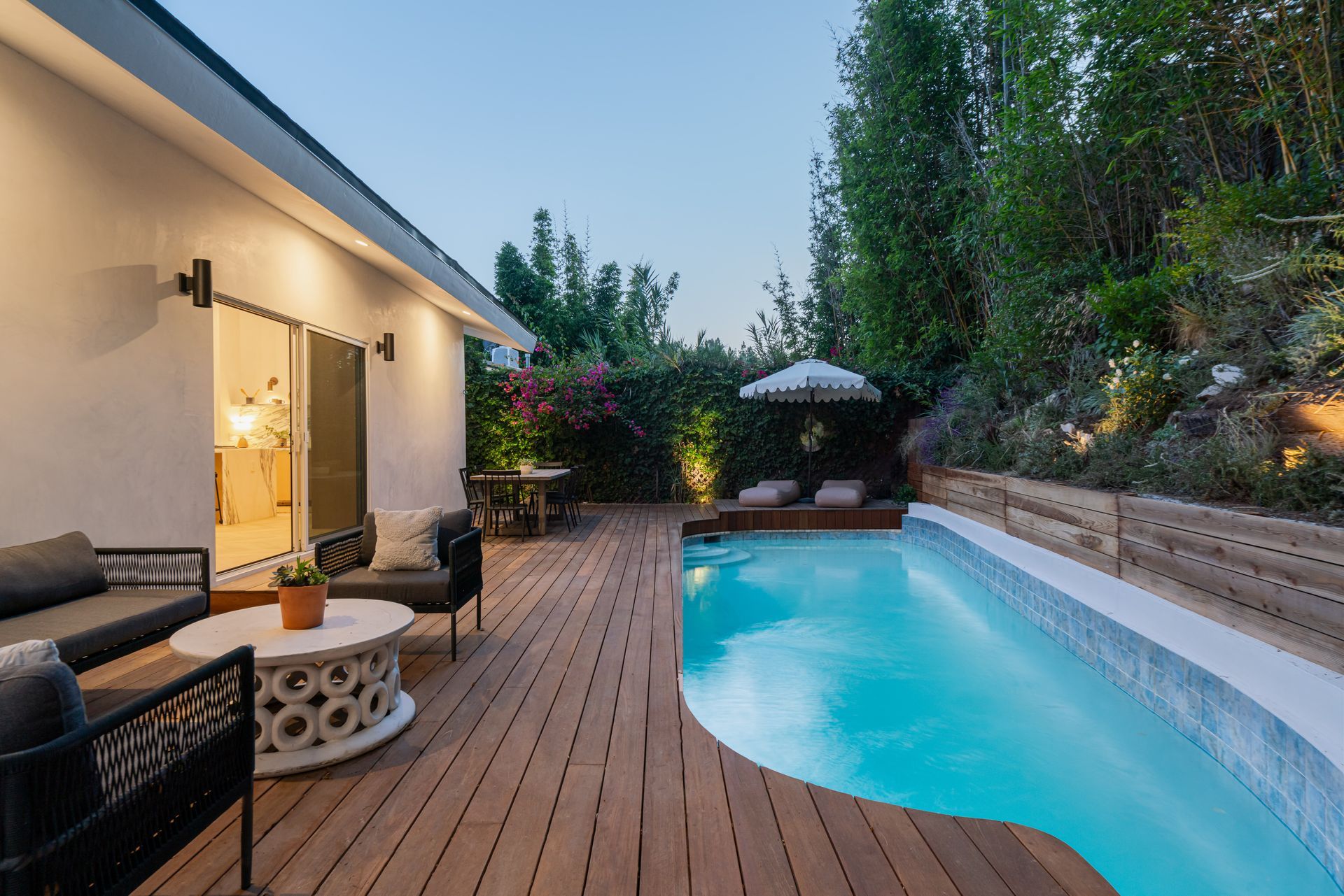There is a large swimming pool in the backyard of a house.