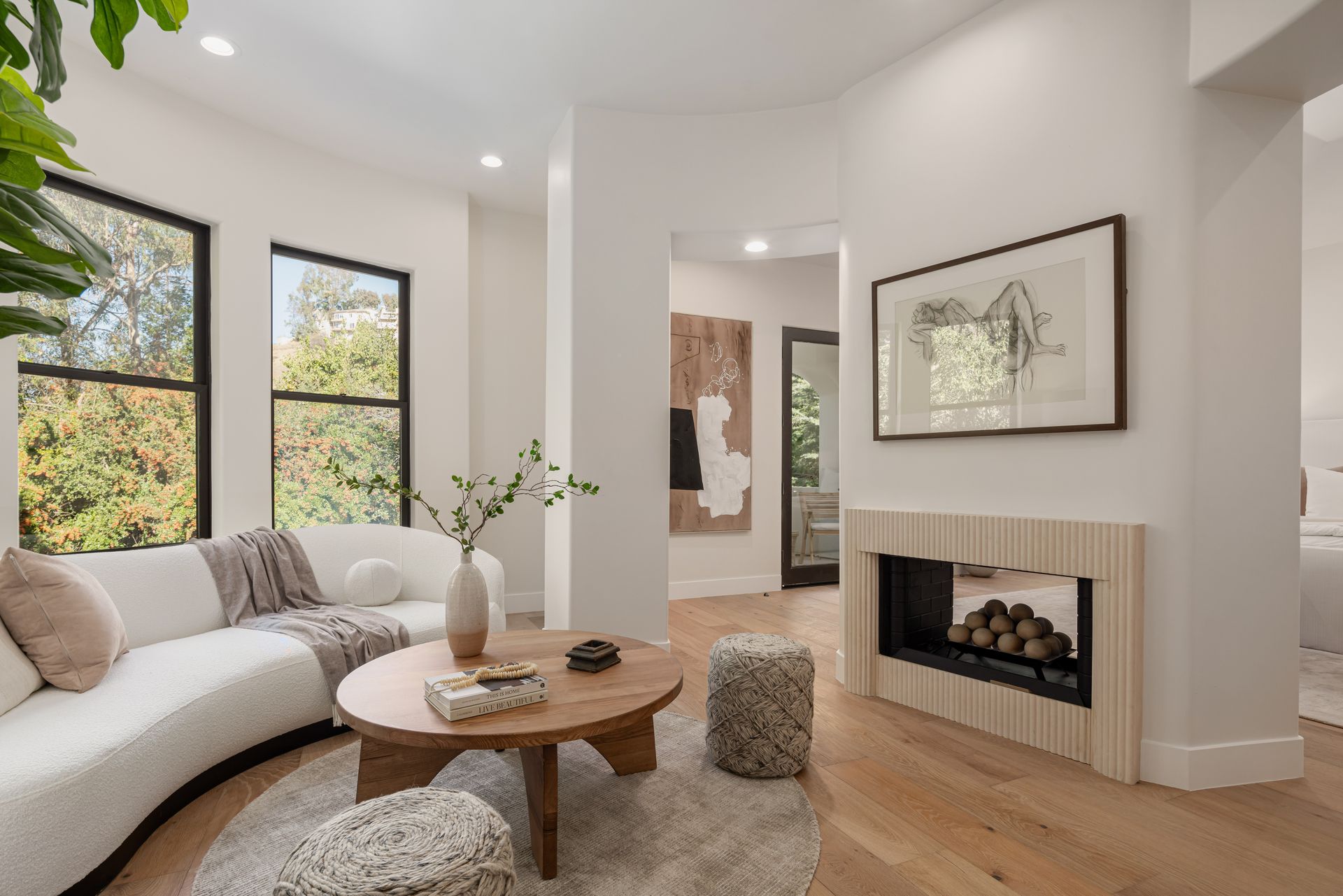A living room with a fireplace , couch , coffee table and ottomans.