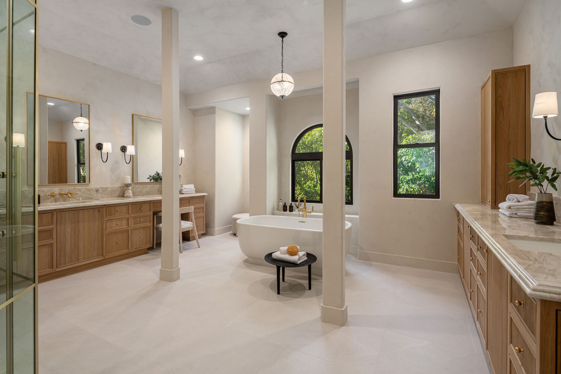 A large bathroom with a tub , sinks , mirrors and a walk in shower.