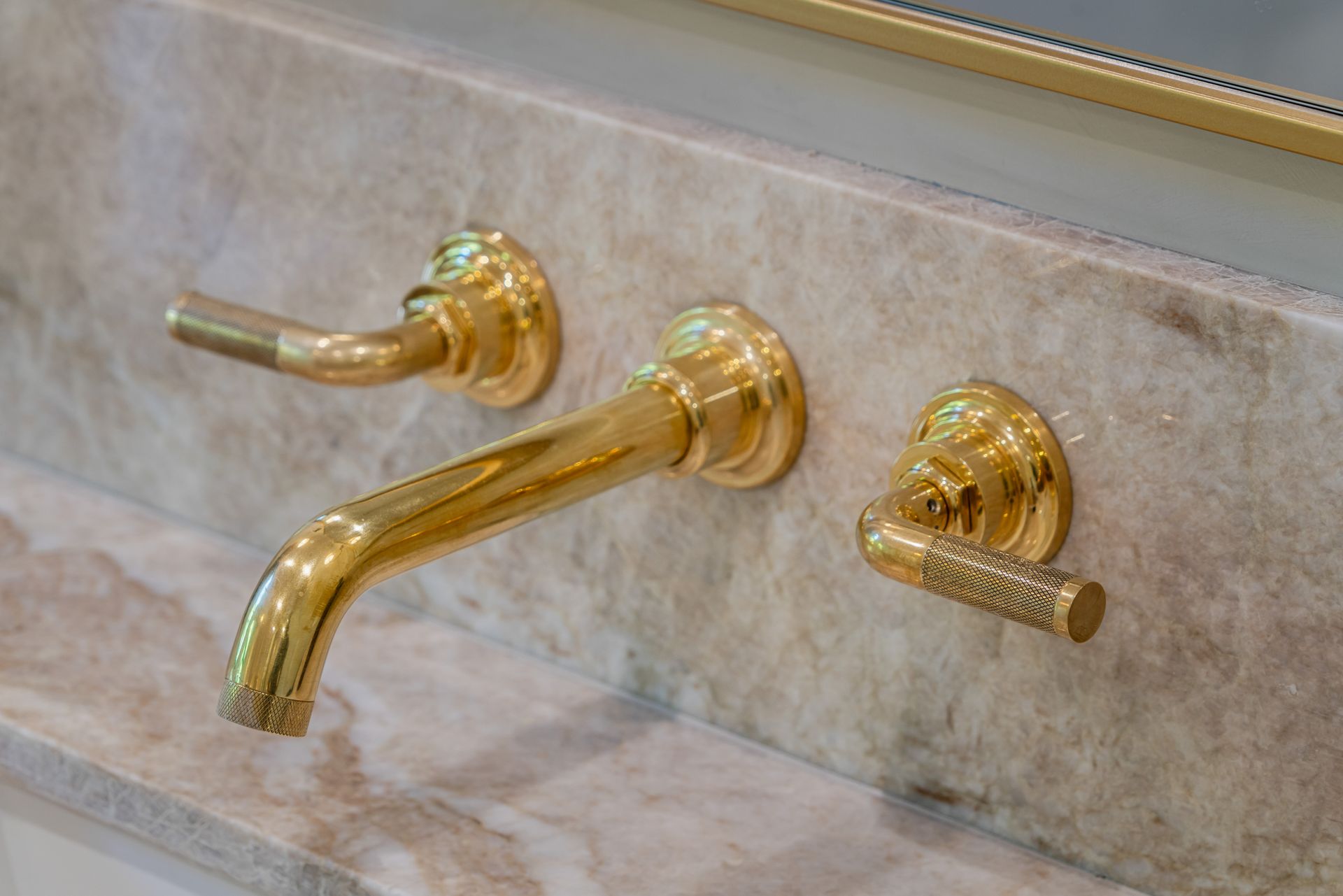 A close-up of a gold faucet on a bathroom sink.