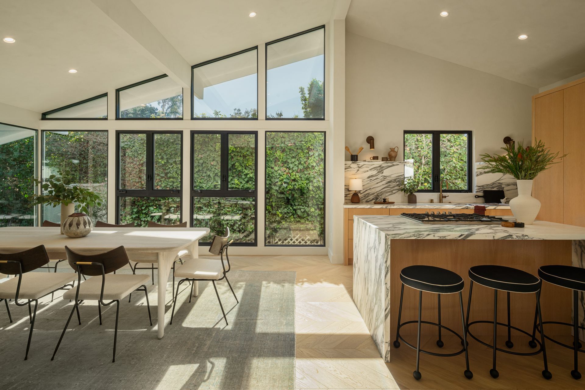 A kitchen and dining room in a house with a lot of windows.
