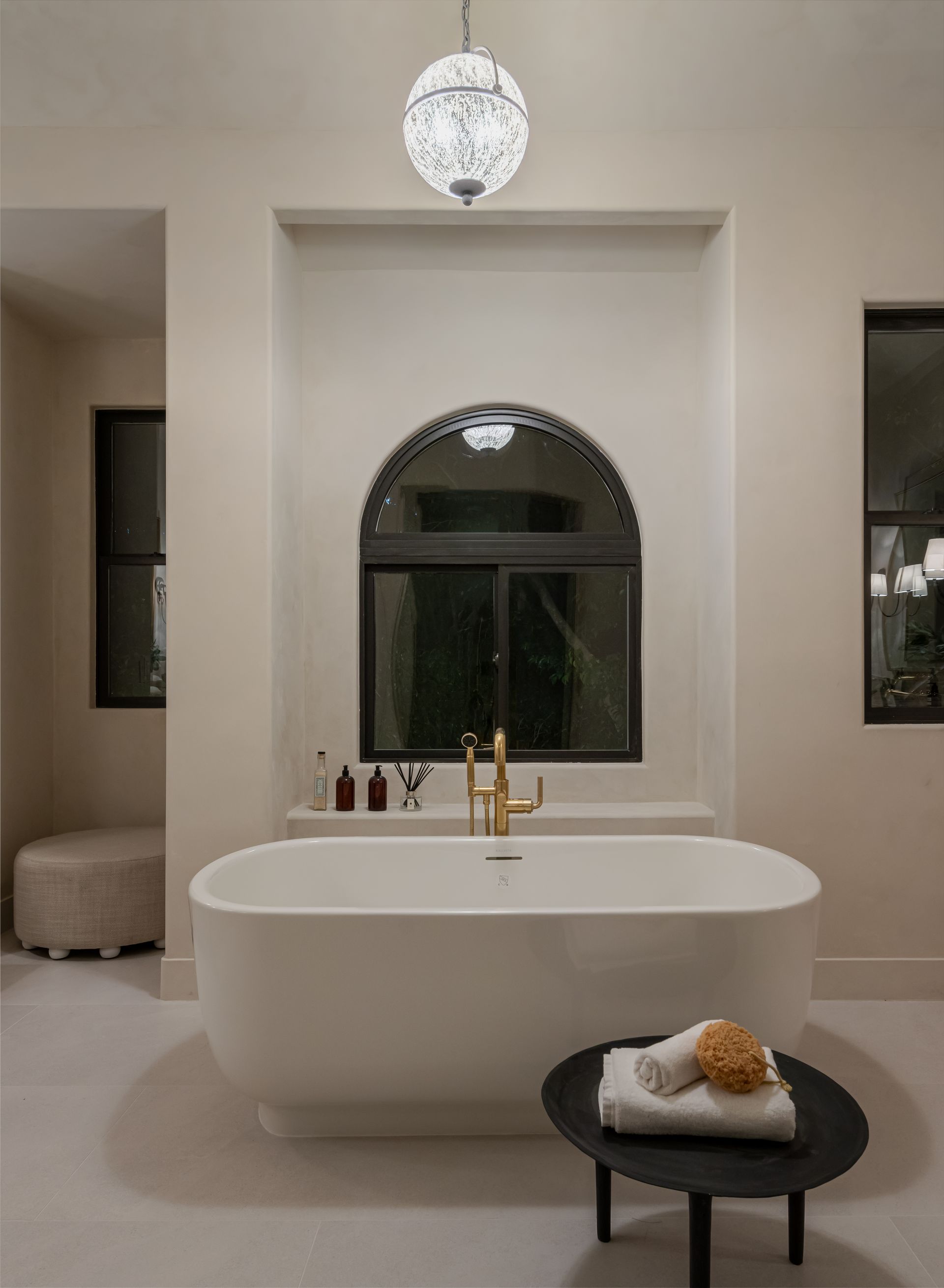 A bathroom with a large bathtub and a window.