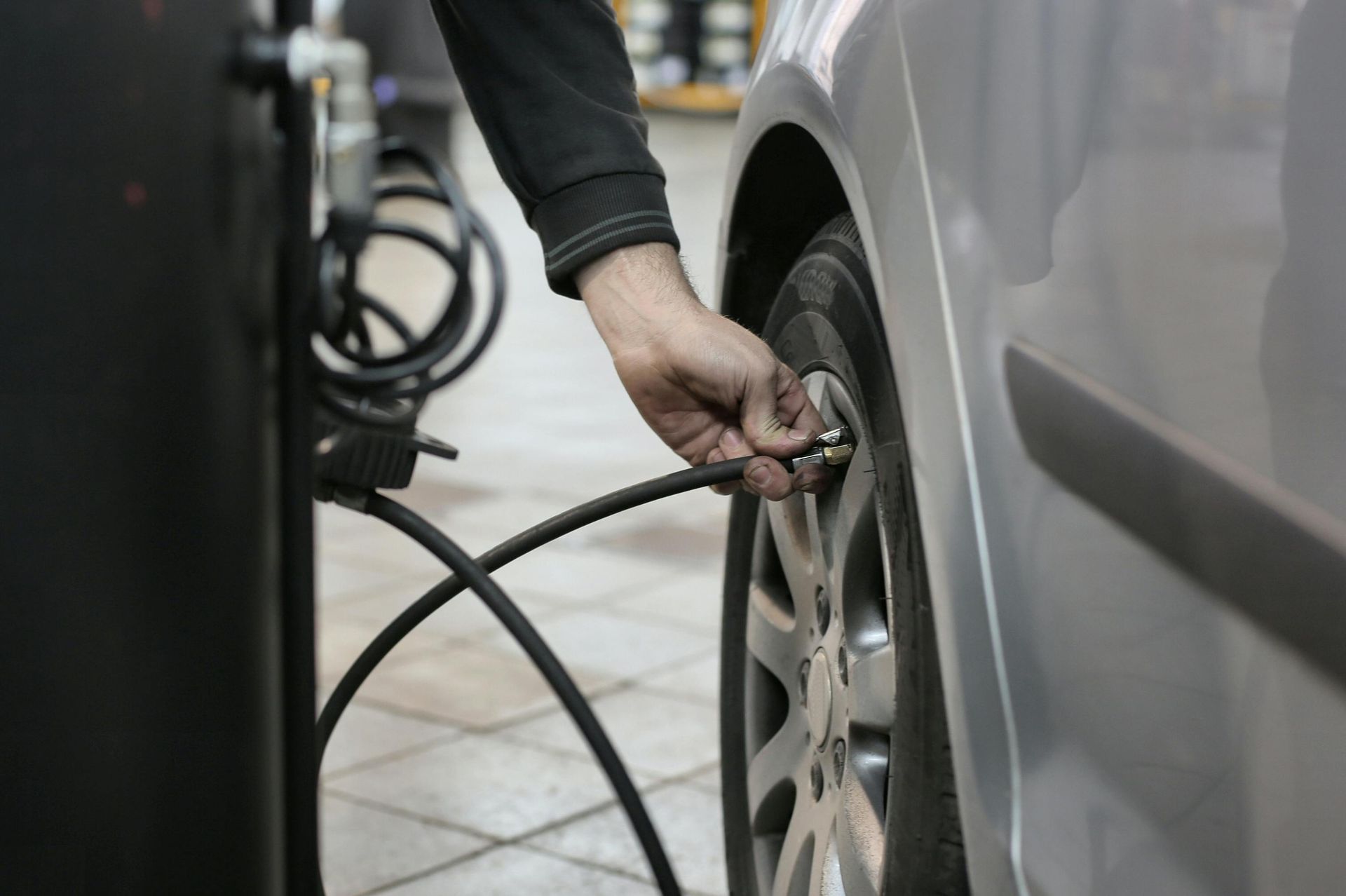 A Person Is Pumping Air Into A Car Tire — Smitty's Tyres & More In Taminda, NSW