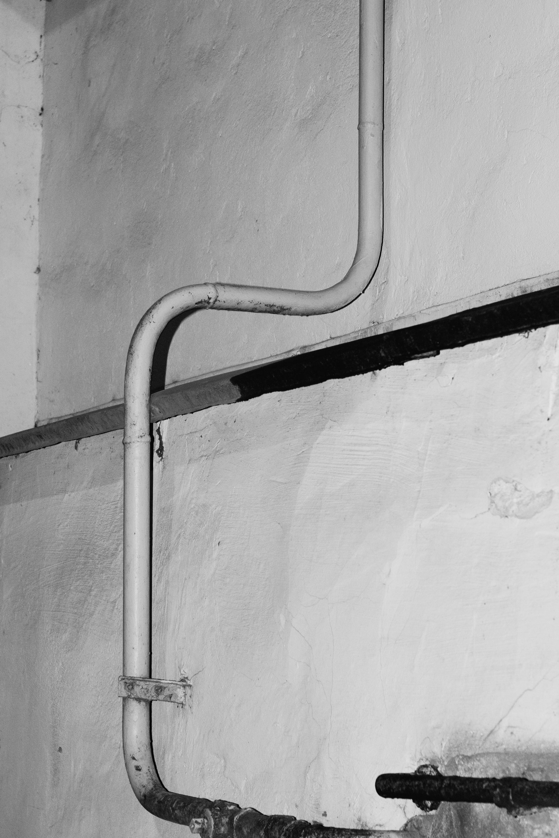 Gloved hand cleaning a white bathroom sink with a gold faucet and drain cover